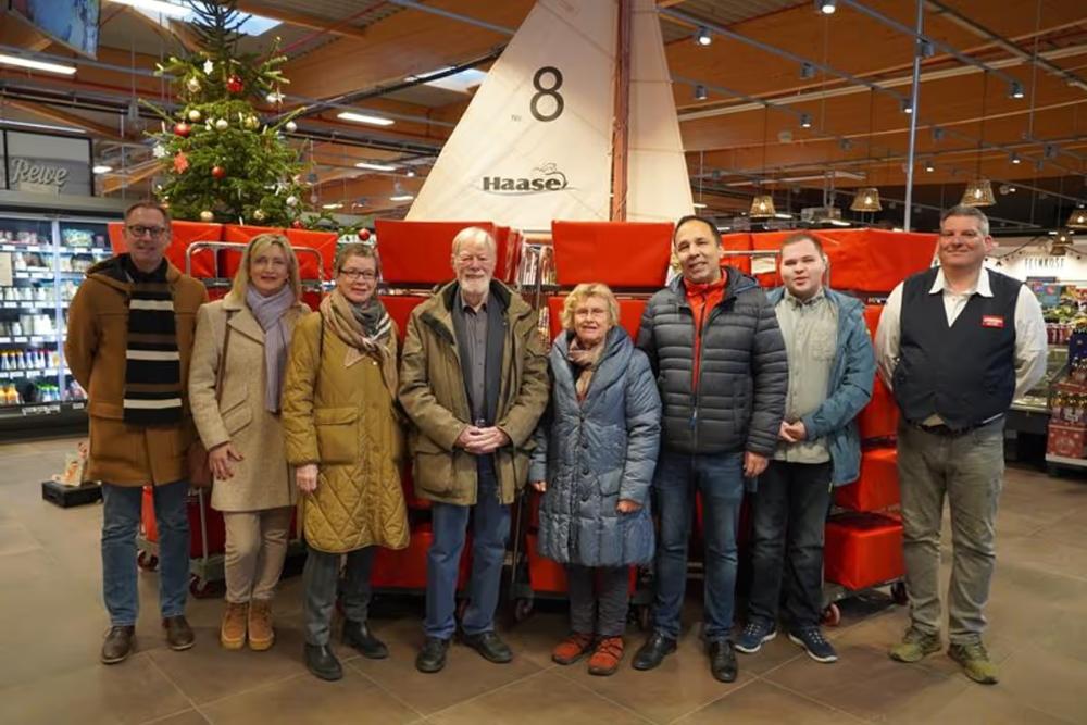 Ralf Hübner (Lions), Lions-Präsidentin Ulrike Baumann, Ulrike Kohlmorgen (DKSB), Dr. Walter Clausen (Lions), Mechtild Piechulla (Vorsitzende DKSB), Robin Pal und Jan-Moritz Wichelmann (beide Stadtkirche) mit Rewe-Marktmanager Thorsten Preuß (v. lks.).